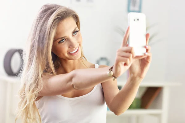Šťastná žena s smartphone na pohovce — Stock fotografie