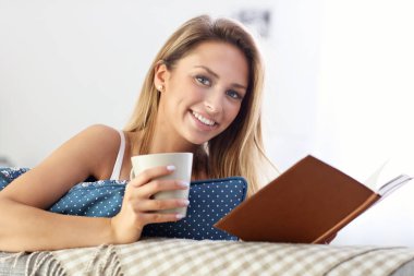 Mutlu kadın kanepe üzerinde okuma