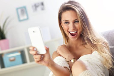 Mutlu kadın kanepede selfie alarak