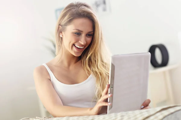 Mujer feliz con tableta en el sofá — Foto de Stock