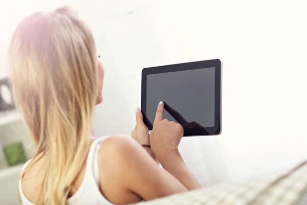 Femme heureuse avec tablette sur canapé — Photo