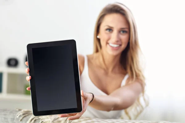 Mujer feliz con tableta en el sofá —  Fotos de Stock