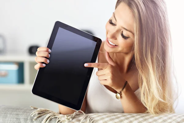 Mujer feliz con tableta en el sofá — Foto de Stock