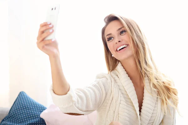 Ευτυχισμένη γυναίκα λήψη selfie στο κρεβάτι — Φωτογραφία Αρχείου