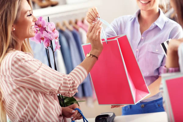 Cliente femenino que recibe bolsas de compras en boutique — Foto de Stock