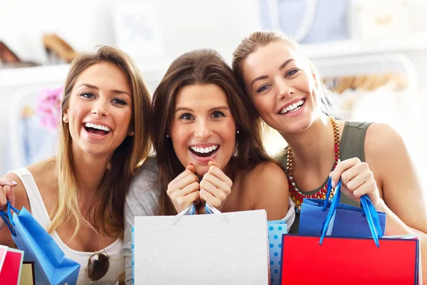 Group of happy friends shopping in store — Stock Photo, Image