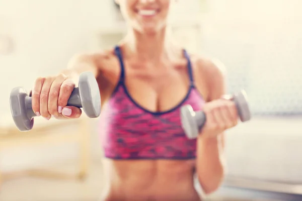 Mujer haciendo ejercicio con pesas en casa — Foto de Stock