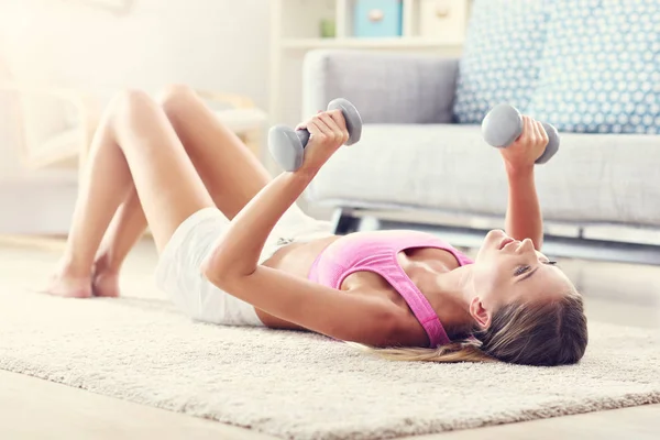 Woman exercising with dumbbells at home — Stock Photo, Image