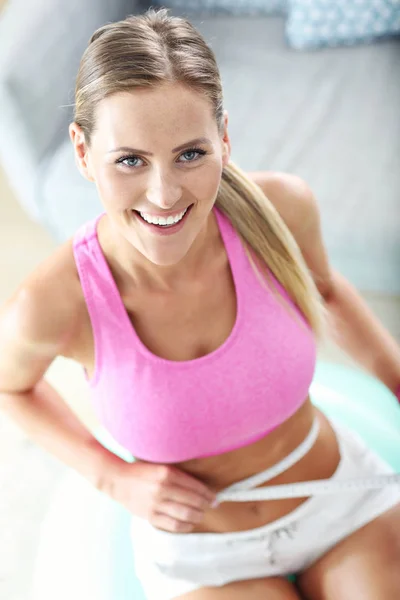 Slim young woman measuring her waist — Stock Photo, Image