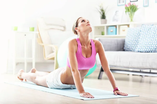 Young woman stretching at home — Stock Photo, Image