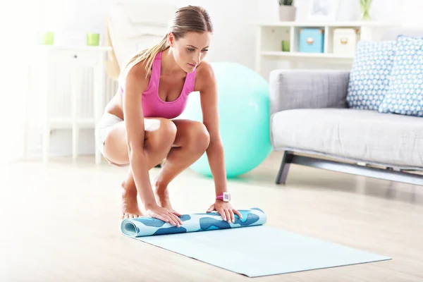 Jeune femme tenant un tapis de yoga — Photo