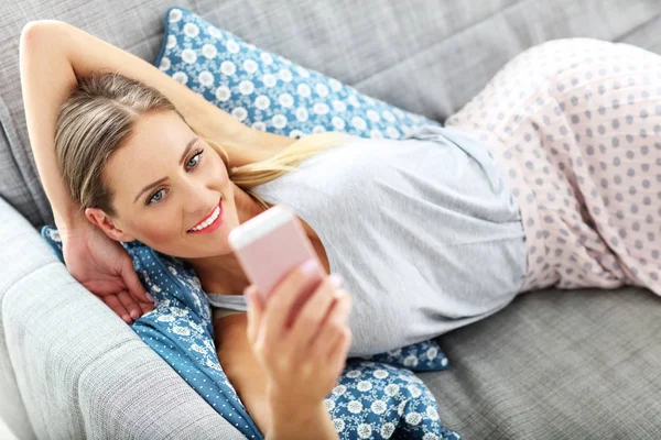 Mulher feliz com smartphone em casa — Fotografia de Stock