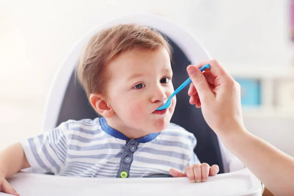 Mum spoon-feeds the child — Stock Photo, Image