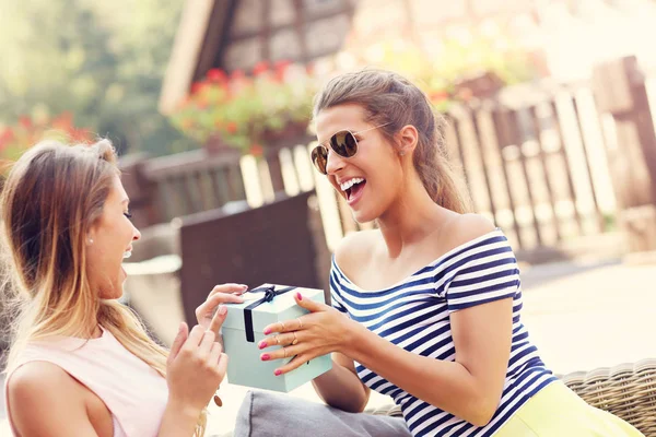 Una foto de dos amigas haciendo un regalo de cumpleaños sorpresa — Foto de Stock