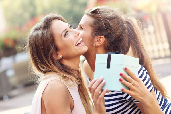 Ein Bild von zwei Freundinnen, die ein Überraschungsgeschenk zum Geburtstag machen — Stockfoto
