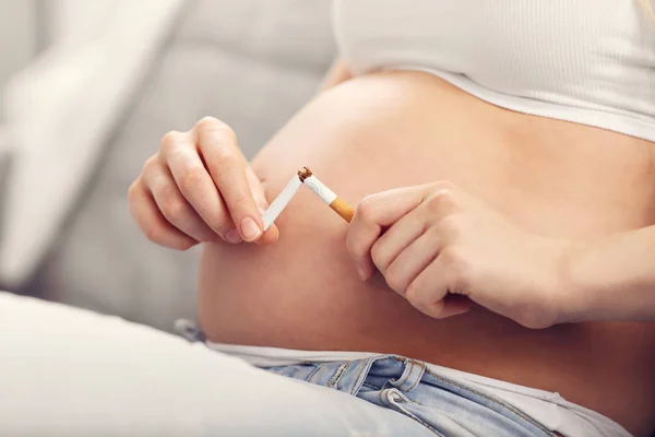 Mulher grávida quebrando cigarro — Fotografia de Stock