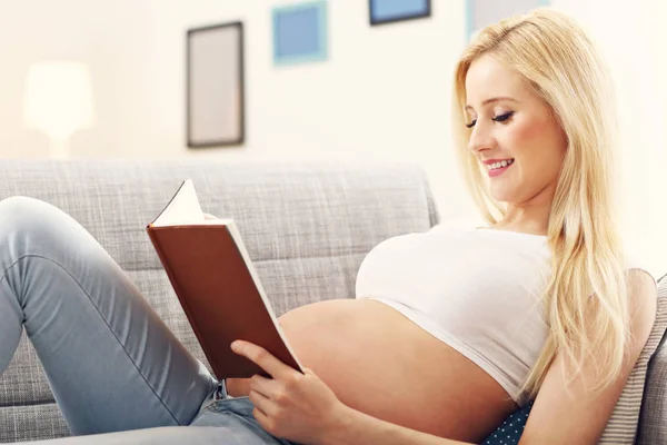 Glückliche schwangere Frau ruht sich auf Sofa aus — Stockfoto