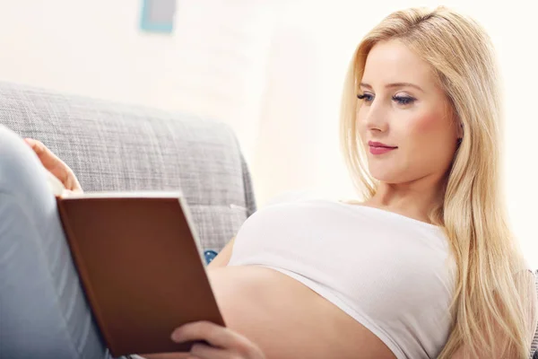 Glückliche schwangere Frau ruht sich auf Sofa aus — Stockfoto