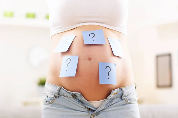 Mujer embarazada con signos de interrogación — Foto de Stock
