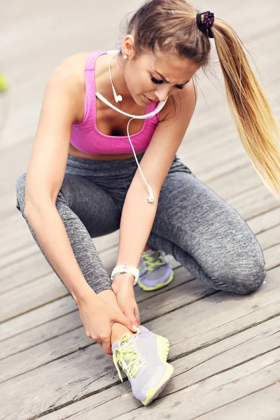 Female athlete runner touching foot — Stock Photo, Image