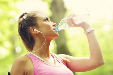 Şişe su ile ormanda koşu kadın