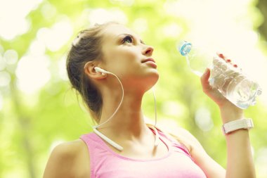 Şişe su ile ormanda koşu kadın