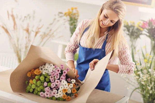 Wanita penjual bunga bekerja di toko bunga — Stok Foto