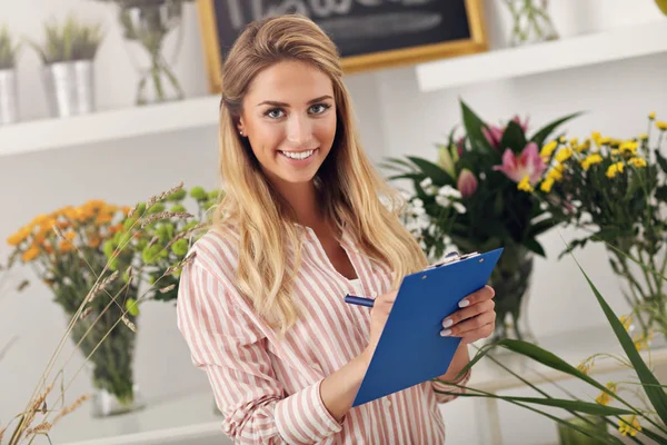 Floristería femenina trabajando en floristería — Foto de Stock