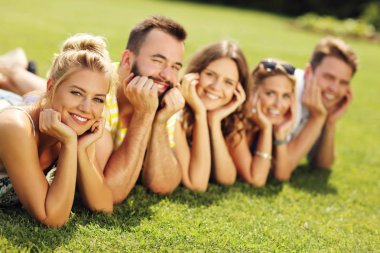 Arkadaş grubu çimenlerin üzerinde birlikte eğleniyor