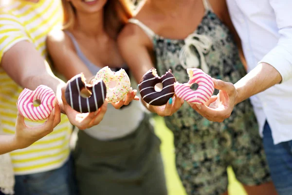 Grupo de amigos comiendo rosquillas — Foto de Stock