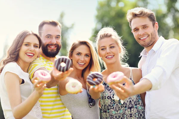 Group of friends eating donuts — Stock Photo, Image