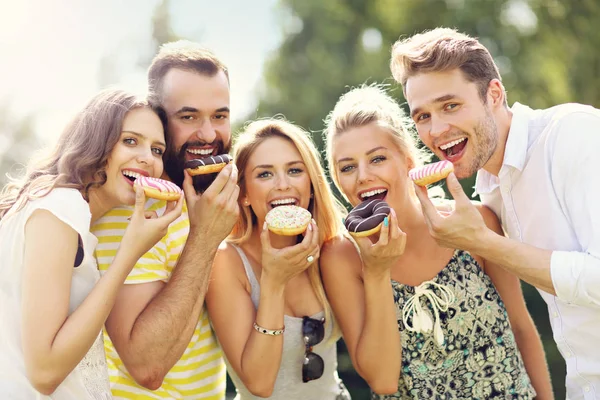 Grupo de amigos comiendo rosquillas — Foto de Stock