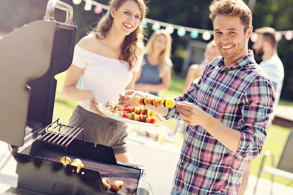 Venner som har grillfest – stockfoto