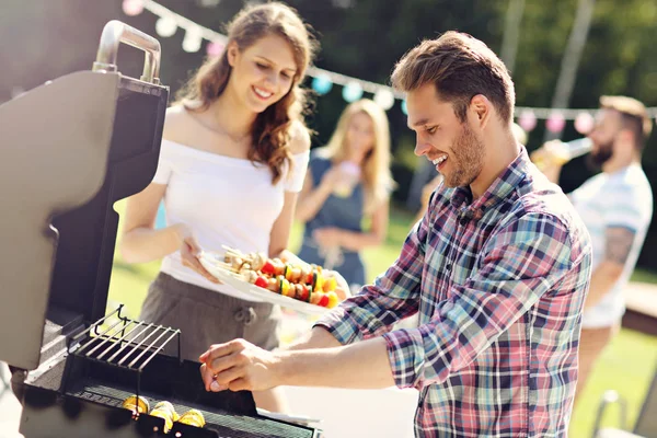 Venner som har grillfest – stockfoto