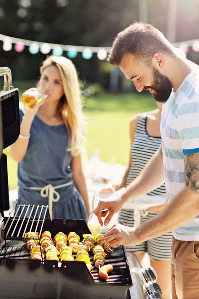 Venner som har grillfest – stockfoto