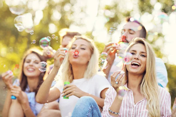 Amigos soplando burbujas al aire libre — Foto de Stock