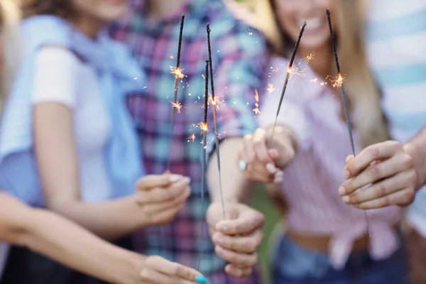 Vrienden having vermaak van wonderkaarsen — Stockfoto