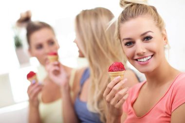 Üç güzel genç kadın evde dondurma yemek