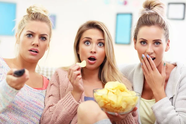 Trois belles jeunes femmes regardant la télévision à la maison — Photo