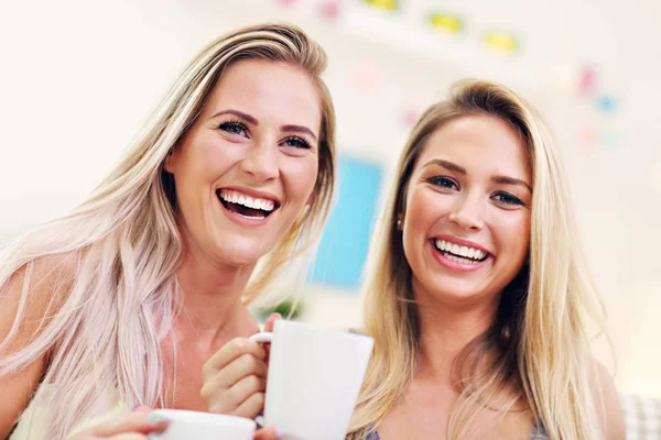 Twee vriendinnen chatten en drinken koffie thuis — Stockfoto