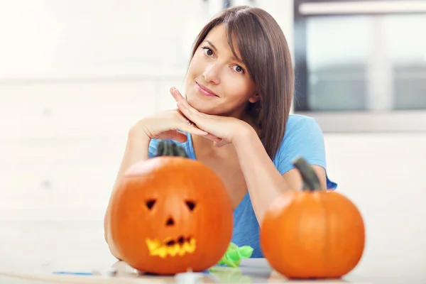 Young woman making jack-o-lantern — Stock Photo, Image