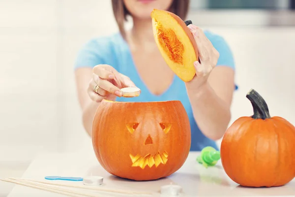 Young woman making jack-o-lantern — Stock Photo, Image