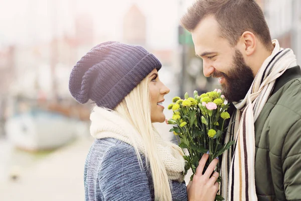Obrázek ukazuje mladý pár s květinami randění ve městě — Stock fotografie