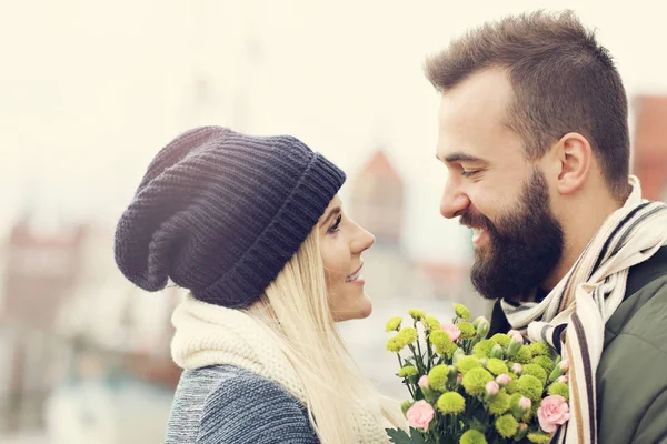 Imagen que muestra pareja joven con flores citas en la ciudad —  Fotos de Stock