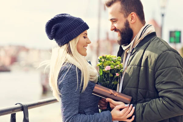 Picture showing young couple with flowers dating in the city — Stock Photo, Image