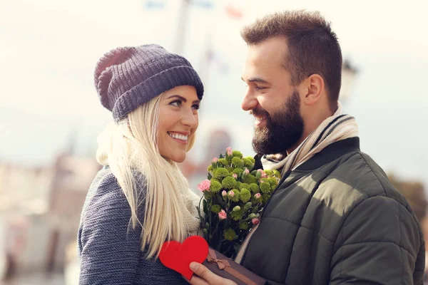 Picture showing young couple with flowers dating in the city — Stock Photo, Image