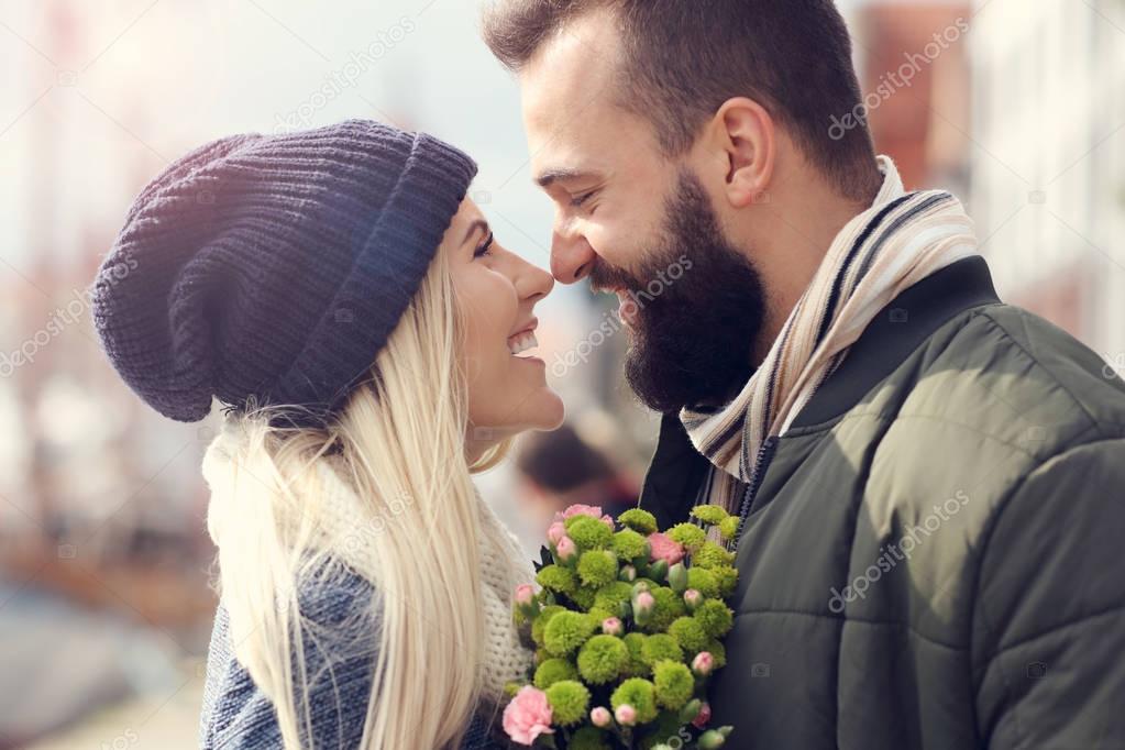 Picture showing young couple with flowers dating in the city