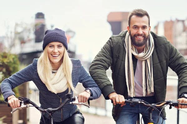 Pareja joven montando bicicletas y divirtiéndose en la ciudad — Foto de Stock