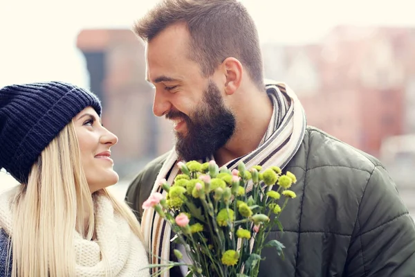Imagen que muestra pareja joven con flores citas en la ciudad — Foto de Stock