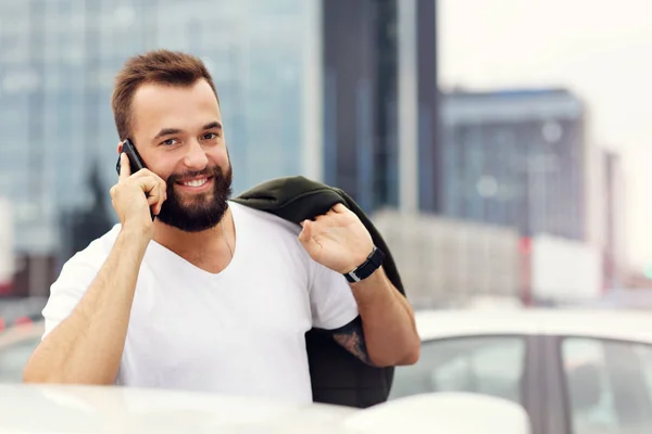 Uomo d'affari in città con il cellulare in mano — Foto Stock